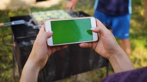 Slow motion woman's hand using a phone with a horizontal green screen on the Stock Footage 94530390