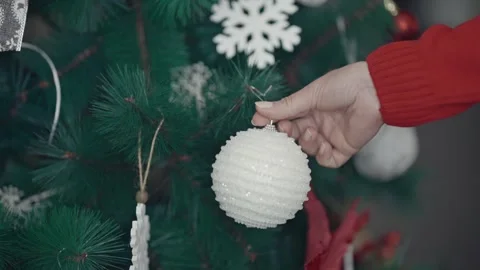 Slow motion of woman's hands putting bauble on the Christmas tree. Preparing  Video stock 252383123