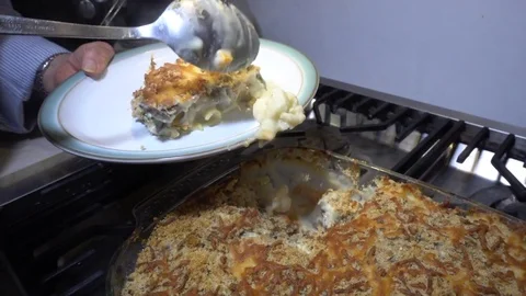 Slow motion: Woman’s hands scooping hot food onto a plate. Stock Footage 79621725