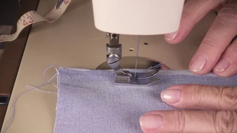 Slow motion women's hands stitch the fabric on the sewing machine Stock Footage 93036658