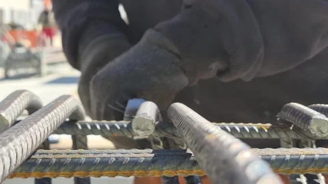Slow motion of worker assembling steel reinforcement bars on scaffolding Stock Footage 333248950