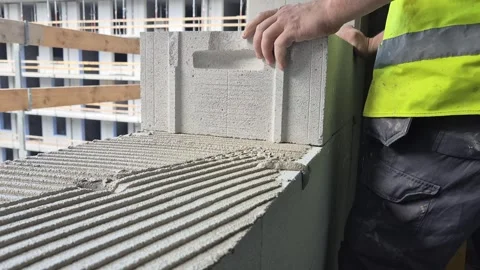 Slow Motion Worker Building Aerated Concrete Wall with Spirit Level Stock Footage 340523326