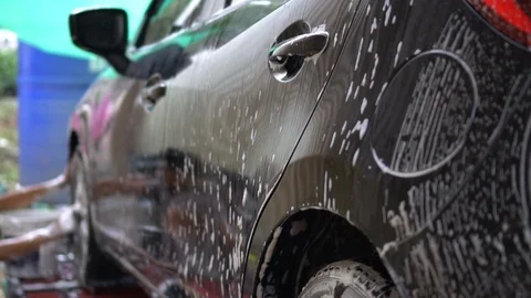 Slow motion worker in car wash service used sponge to cleaning and washing a  Video stock 100228527