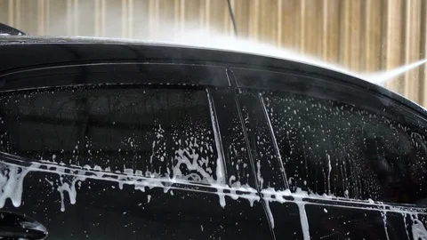 Slow motion worker in car wash service used high pressure water jet cleaning  Video stock 100228932