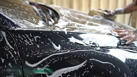 Slow motion worker in car wash service used sponge to cleaning and washing a  Video stock 100228939