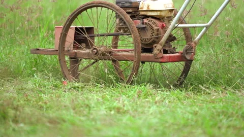 Slow motion worker cutting grass in sports field by mower Vídeos de archivo 142008846