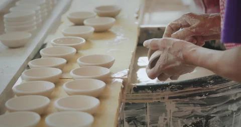 Slow motion, worker dipping ceramic bowl from clay onto coating Stock Footage 203234295