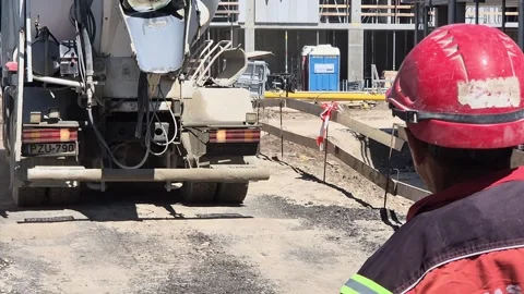 Slow Motion of Worker Guiding Mixer Truck with Hand Signals - Editorial Stock-Footage 334128925