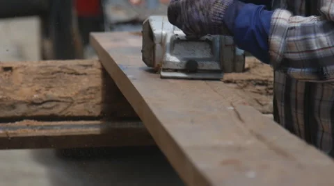Slow motion of worker planing a plank of wood with a electric plane Stock Footage 63258451