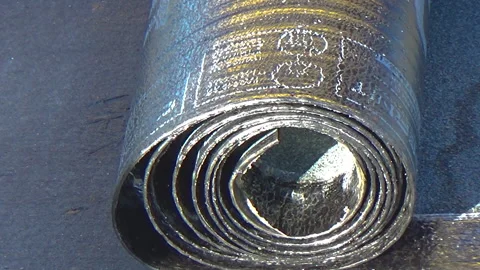 Slow motion. Worker preparing part of bitumen roofing felt roll for melting b Vídeo Stock 131022142