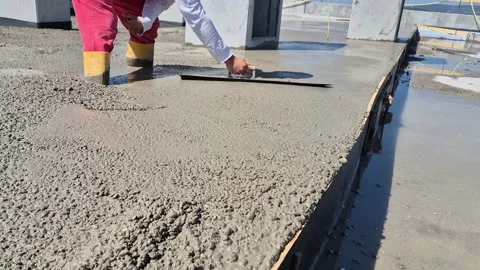 Slow motion of worker smoothing fresh concrete with hand trowel Stock Footage 340157337