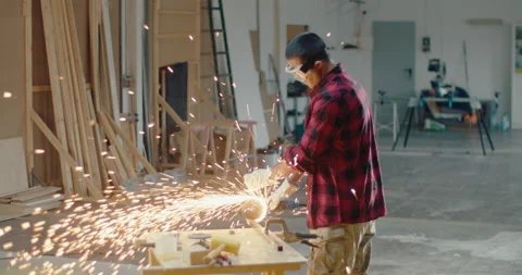 Slow motion of worker using an angle grinder machine to cut metal in the Stock Footage 199624618