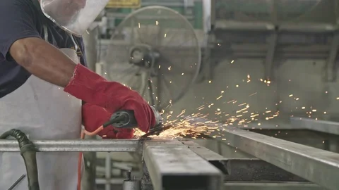 Slow motion of a worker using metal grinder with sparks flying at a metal shop Stock Footage 109456889