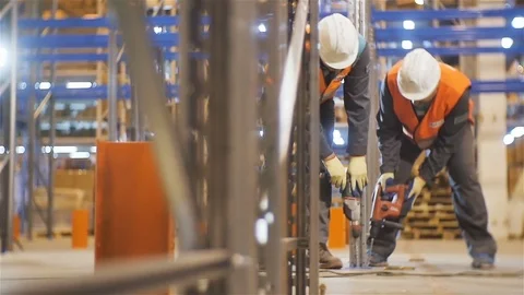 Slow Motion Workers Fix with Drills Metal Racks in Warehouse Stock Footage 81824783