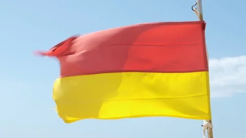 Slow motion yellow and red flag on beach meaning that life guards are present Stock Footage 115759360