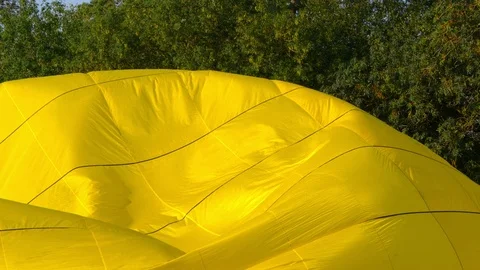 Slow motion yellow balloon envelope sail inflating for the flight. Stock Footage 114302610