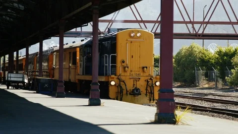 Slow motion yellow train pulling into station Stock Footage 88380250