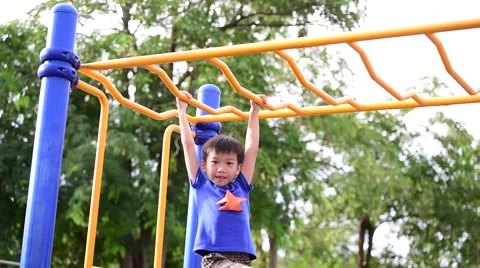 Slow motion, Young asian boy hang the yellow bar by his hand to exercise at o 库存影片 67830673