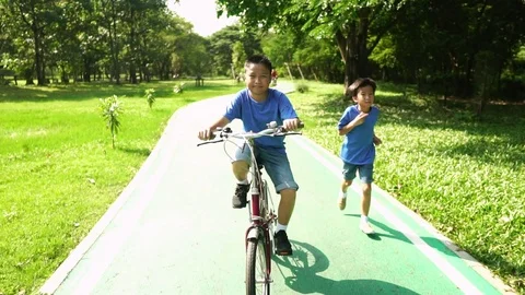 Slow motion of Young Asian boy cycling and running in a park 库存影片 88437542