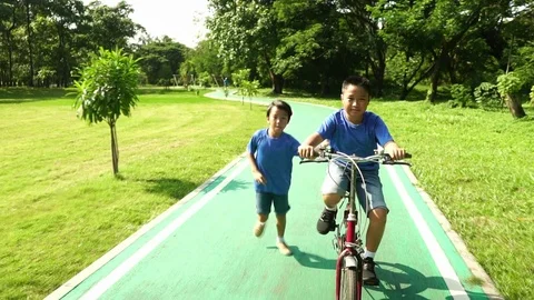 Slow motion of Young Asian boy cycling and running in a park 库存影片 88766642