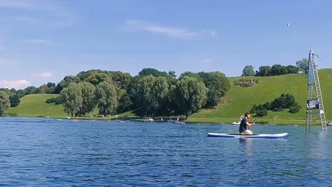 Slow motion of Young Attractive Mann on Stand Up Paddle Board Stock Footage 106598176