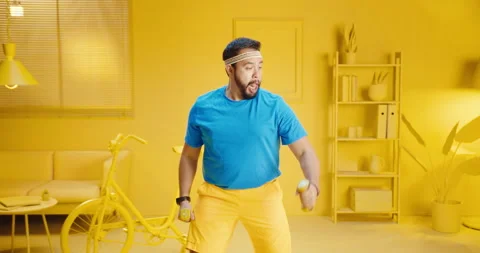 Slow motion of young bearded man exercising with dumbbells and funny expression Stock Footage 165863840