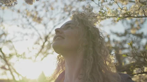 Slow motion of young blonde amazed by surrounding blossoming trees Stock Footage 143081900