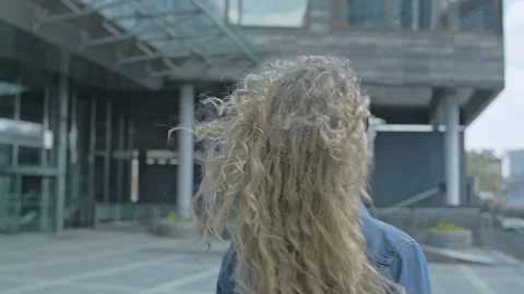 Slow motion of young blonde spinning around with her sunglasses outdoors Stock Footage 143020104