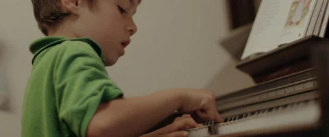 Slow Motion Young Boy Learning to Play the Piano Stock Footage 61470162