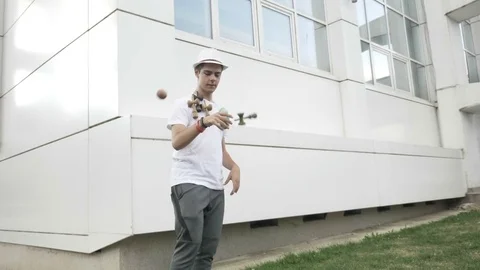 Slow motion of young boy playing with kendama swirling and catching the toy w Stock Footage 81429226