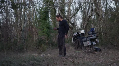 Slow motion young boy standing in the forest consulting his smartphone while he Stock Footage 274737856