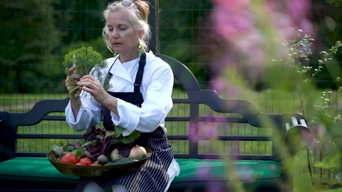 Slow motion of young chef farmer smelling herbs backlit sunlight outside with Stock Footage 135830173