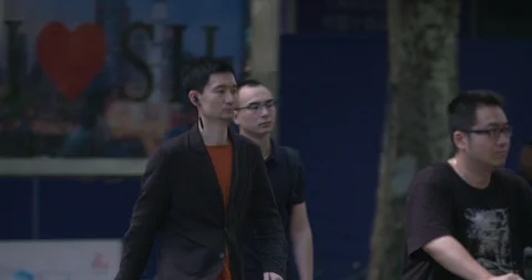 Slow motion young Chinese men walking, modern city Stock Footage 113899746