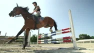 Slow Motion: Young Competitive Rider Girl Training Fence Jumping On Sandy Manege Stock Footage