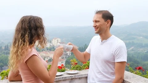 Slow motion of young couple drinking tea on balcony terrace, Chiusi Tuscany Stock Footage 117028367