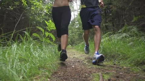SLOW MOTION: A young couple jogging in the forest Stock Footage 32350264