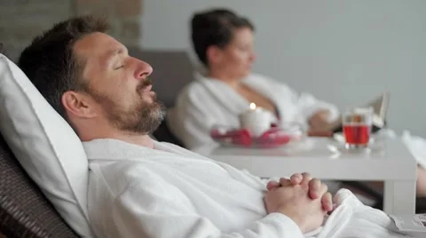 Slow motion of a young couple reading and sleeping in the spa 스톡 동영상 49775888