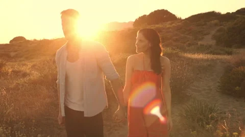 Slow motion of young couple walking on sand dunes in sunset. Stock Footage 43664126