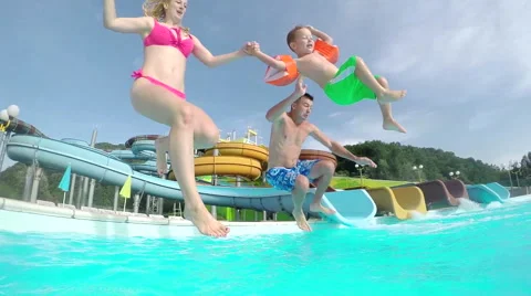 SLOW MOTION: Young family running and jumping into the pool Stock Footage 59141403