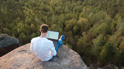 Slow motion of a young freelancer working on a laptop sitting on top of a Stock-Footage 130913032