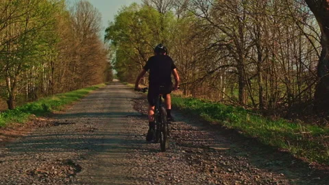 Slow motion - Young  man cyclist rides on a countryside road. Teenager on a m Stock Footage 144170423