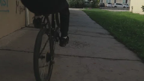 Slow motion of a young man doing a "wheely" on his bicycle Stock Footage 147200850