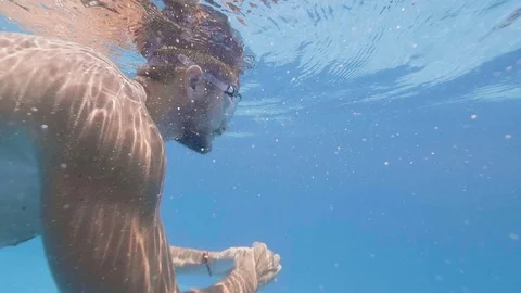 Slow motion young man in goggles swimming underwater outdoor pool in resort Video stock 108194587