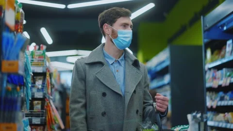 Slow motion young man hold a cart with groceries in the supermarket during the Stock Footage 143739018