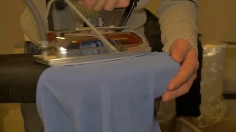 Slow Motion - Young man ironing a women's shirt Stock Footage 85048167