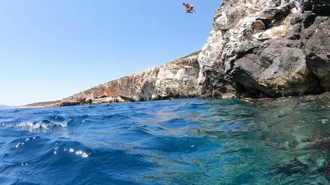 Slow motion of a young man jumping from a cliff, greece Stock Footage 135319819