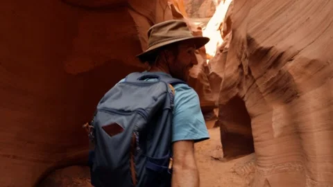 SLOW MOTION: Young man running inside narrow canyon in the desert, Stock Footage 130956853