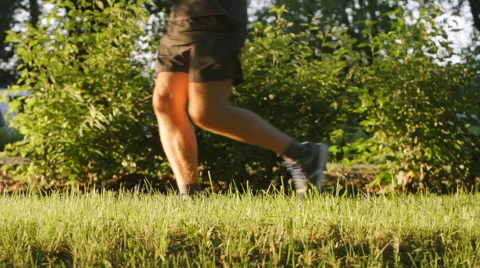 SLOW MOTION: Young man runs on an alley - side view Stock Footage