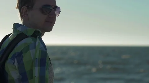 Slow motion, Young man with serious face, turns away from camera in sunglasses Stock Footage 76701378