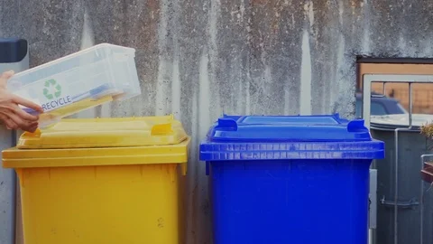 Slow motion of Young Man Sorting Used Plastic Bottles and Paper from other Waste Stock Footage 127260467